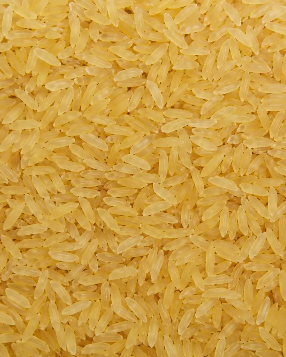 Parboiled rice grains with warm amber color.